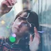 woman holding holiday lights looking at them in wonder