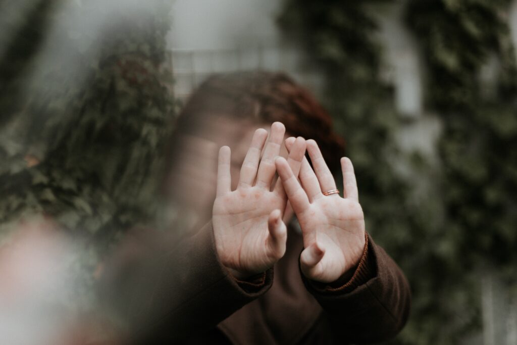 woman holding her hands out in front of her face pushing away from her representing the idea of not trying to save everyone